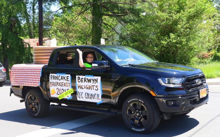 Photo of the Rec Council's Parade Vehicle, It is a black truck with a red picnic blanket and a stack of panacakes in the back 